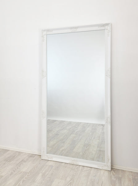 Tall white French-style mirror with ornate carved frame