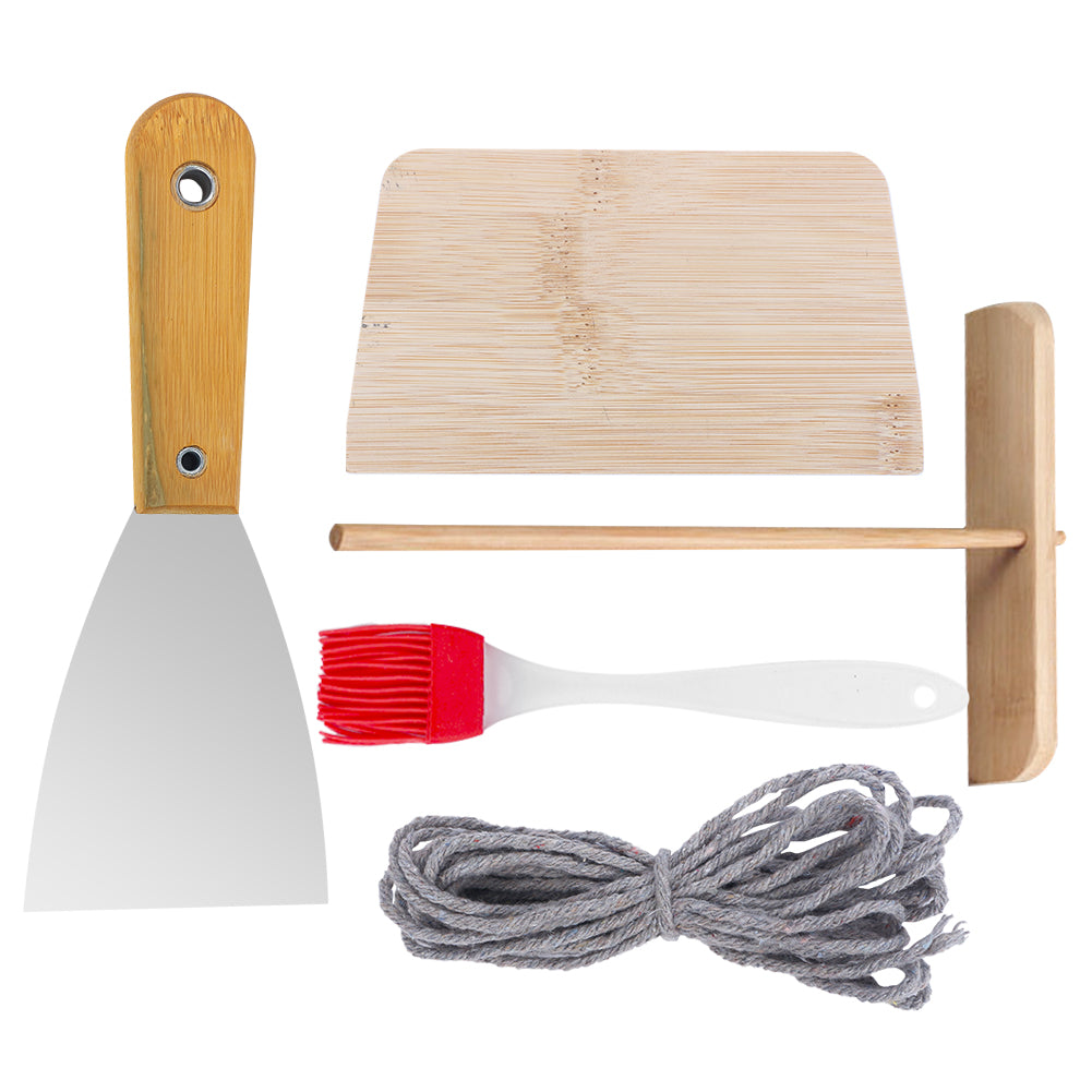 Seasoned cast iron crepes pan with wooden accessories, including brush and scraper