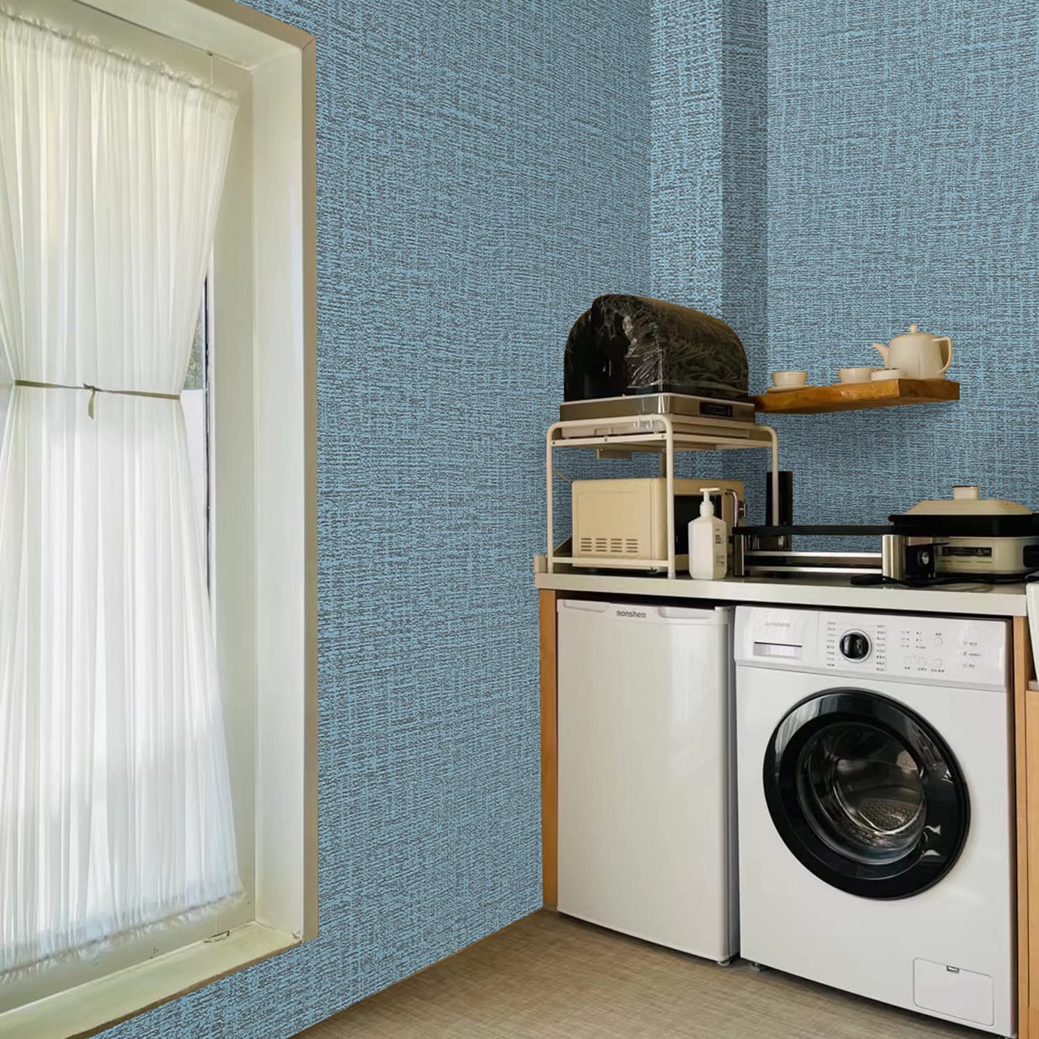 Blue woven-texture wallpaper on wall next to washing machine