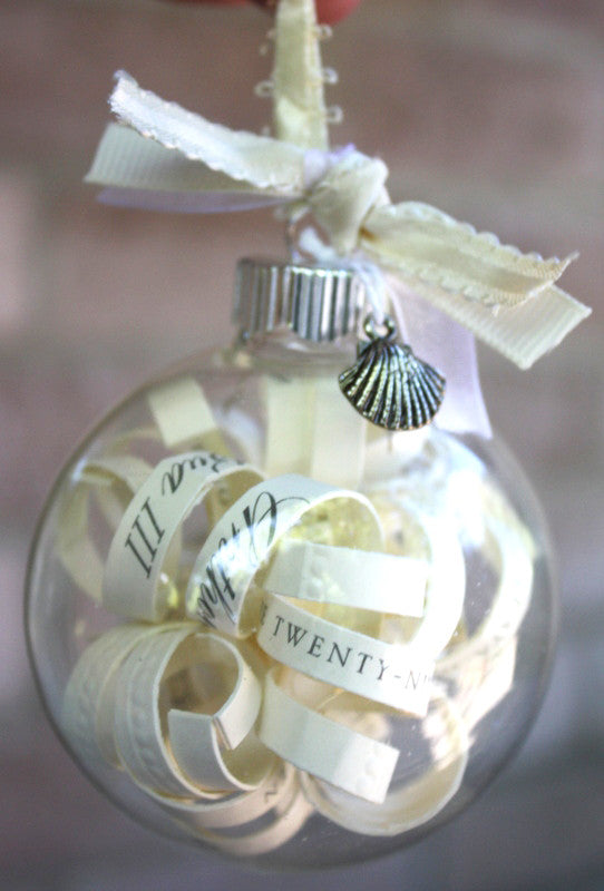 Clear glass bauble with silver cap and curled ribbon inside, round ornament.