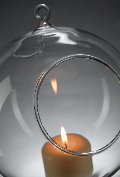 Clear glass hanging ball tealight candle holder with close-up lit tea light