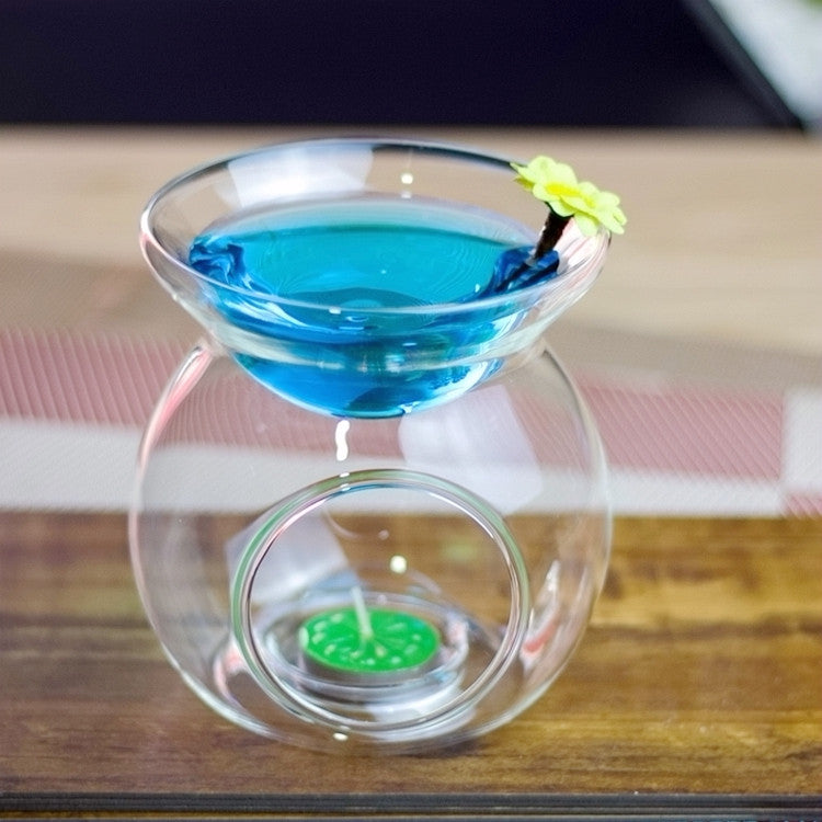 Glass tealight candle warmer with blue liquid top and small green wax tealight inside