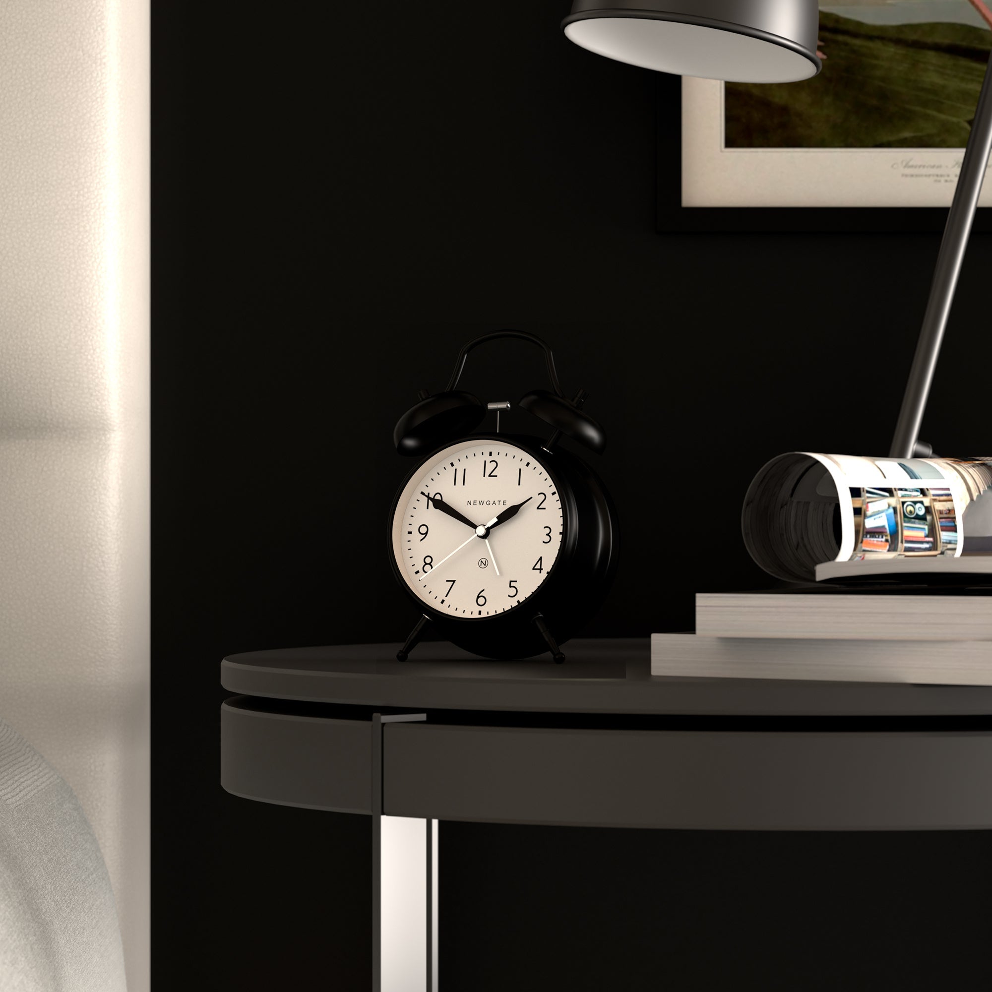 Matte black twin bell alarm clock on a shelf with white dial and black hands