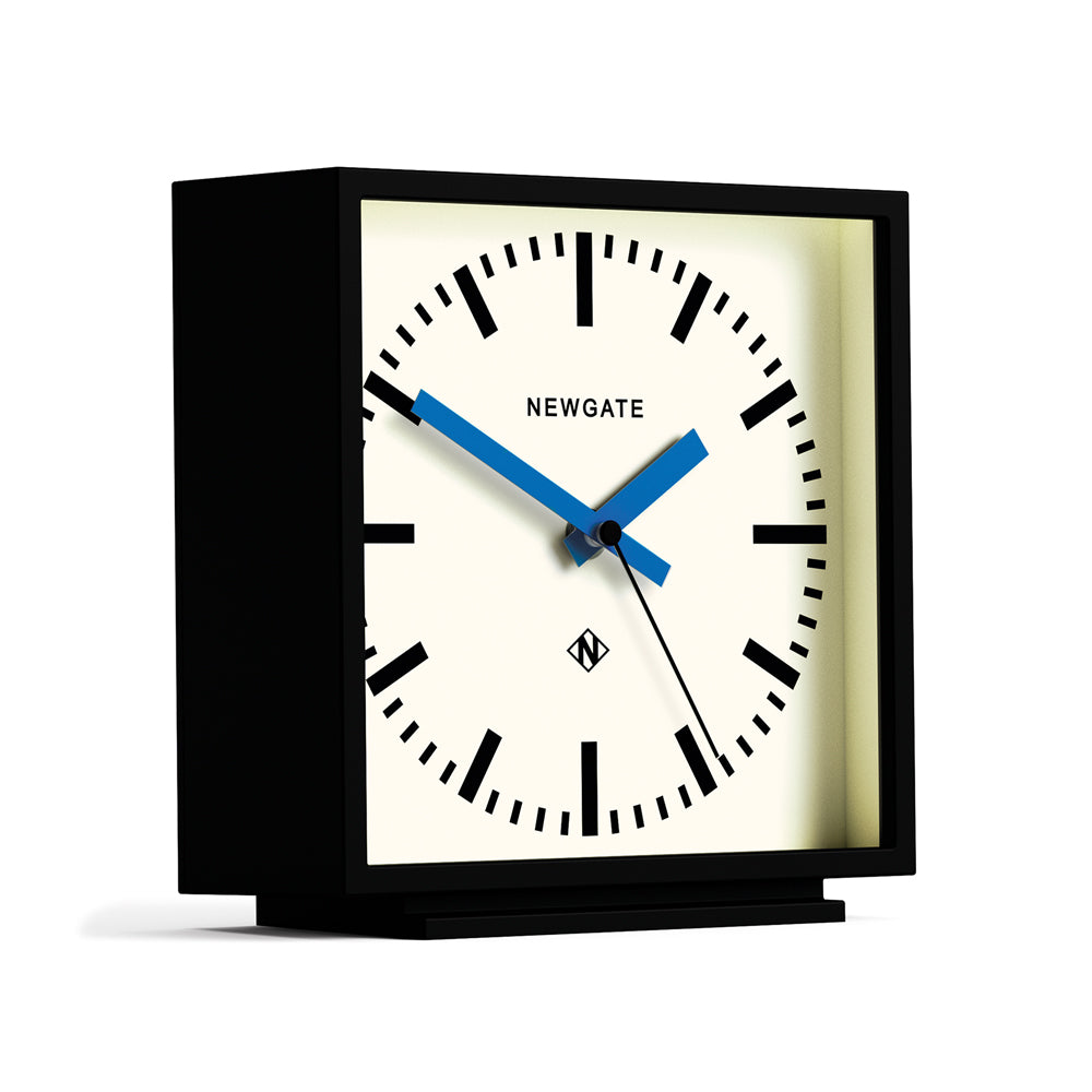 Newgate mantel clock with black case, cream dial, blue hands, angled view