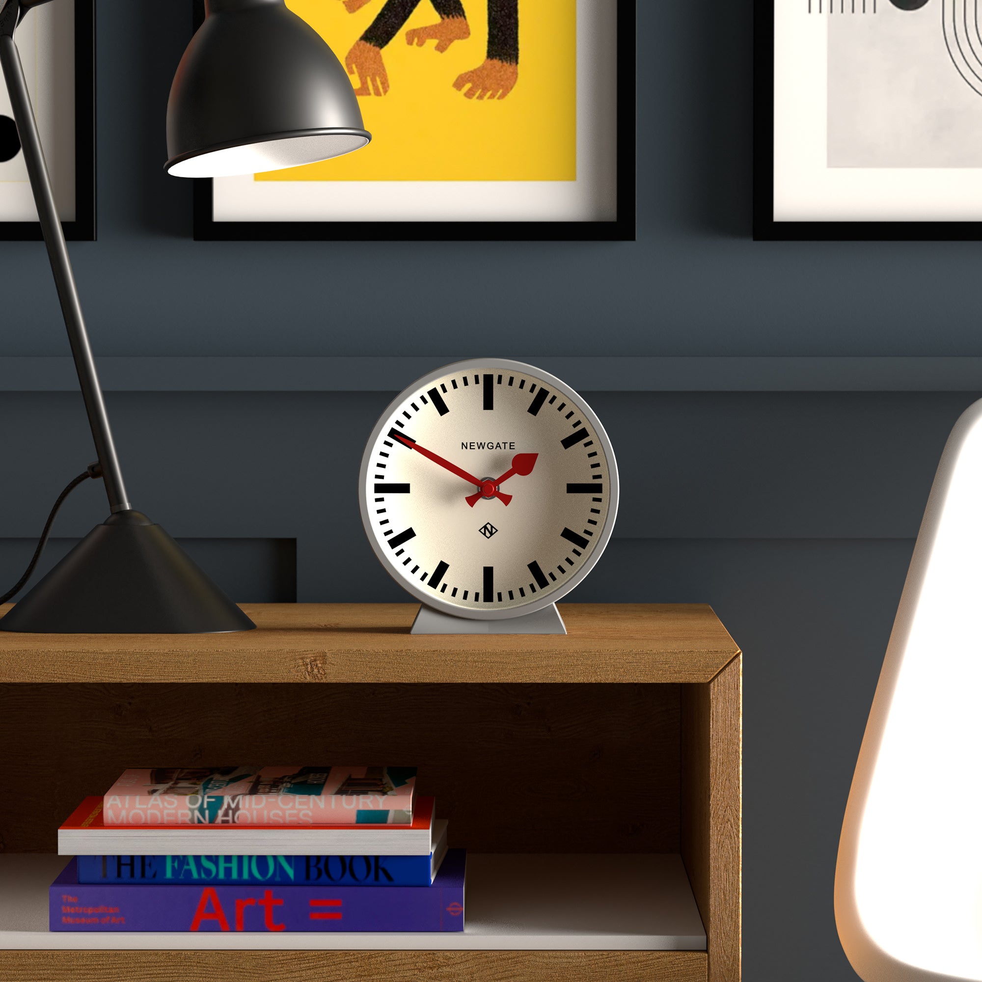 White-dial mantel clock with red hands and black numerals on grey base.