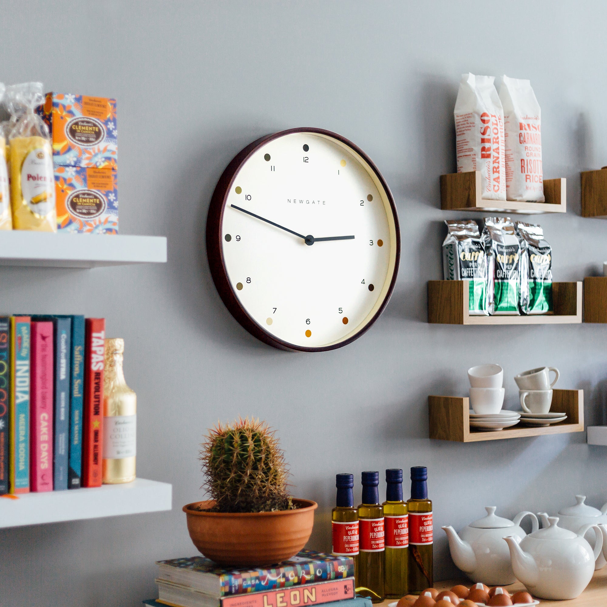 Round wall clock with cream dot dial, black hands, and dark wood frame
