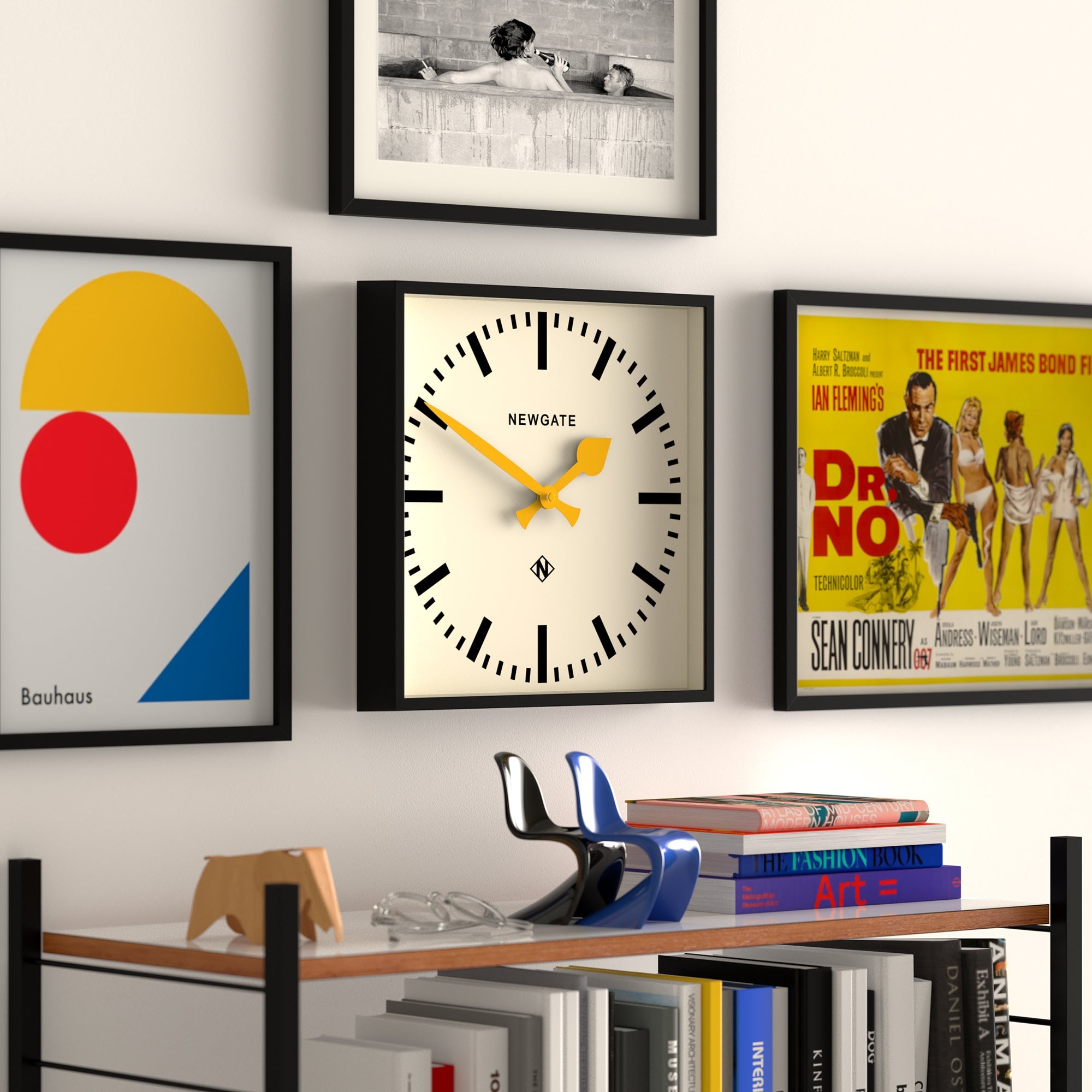 Black-framed wall clock with cream face, yellow hands and bold black minute markers