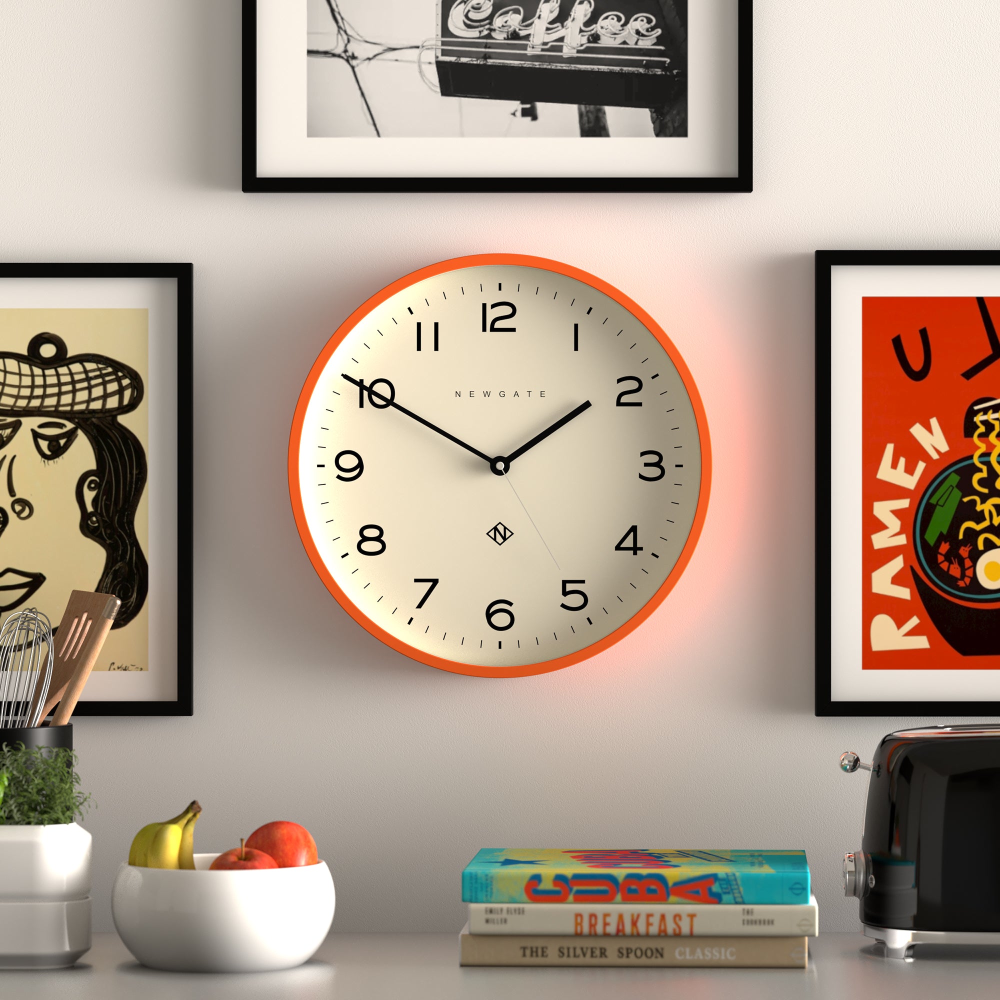 Orange wall clock with black hands and Newgate logo on cream face