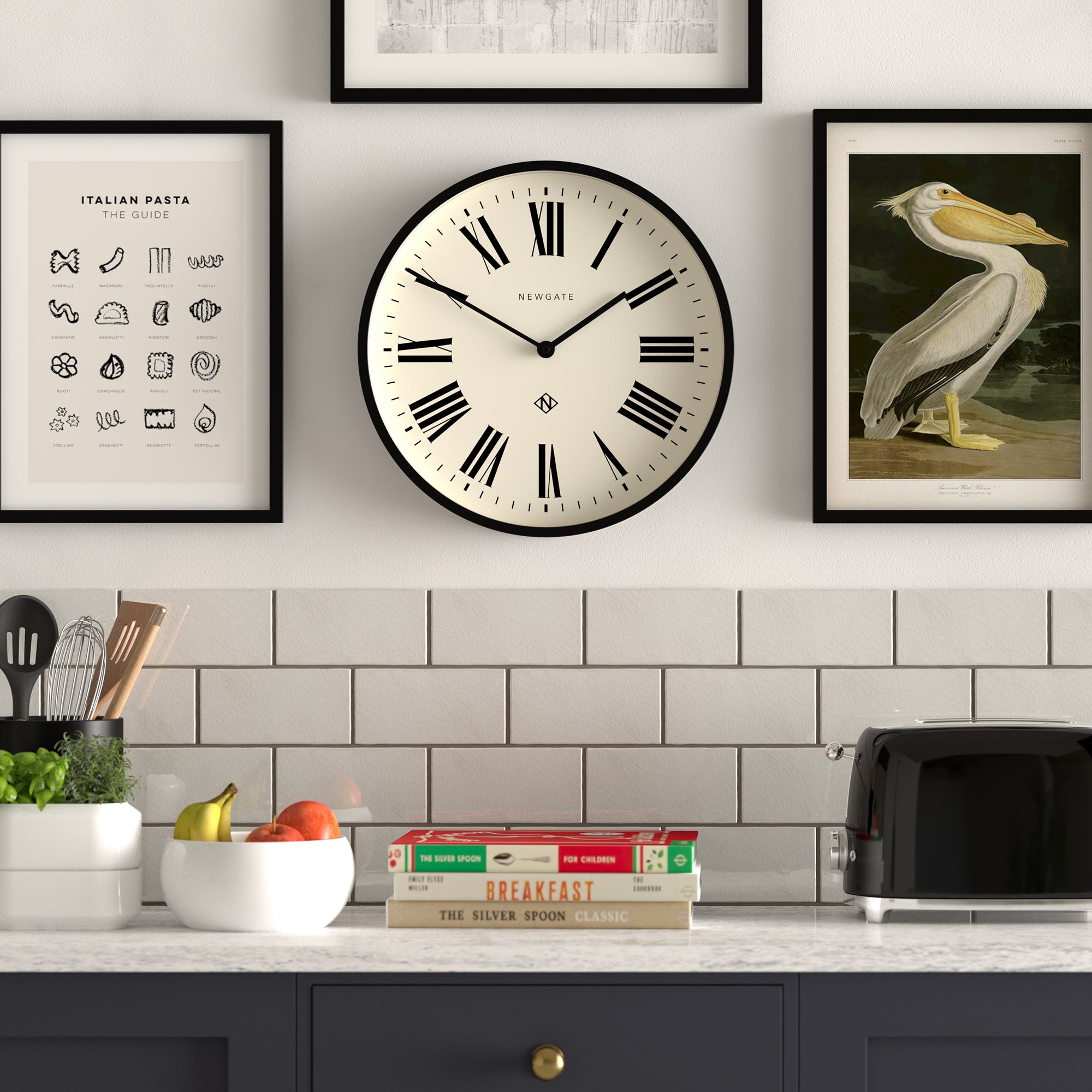 Black-framed wall clock with cream dial, Roman numerals and central logo