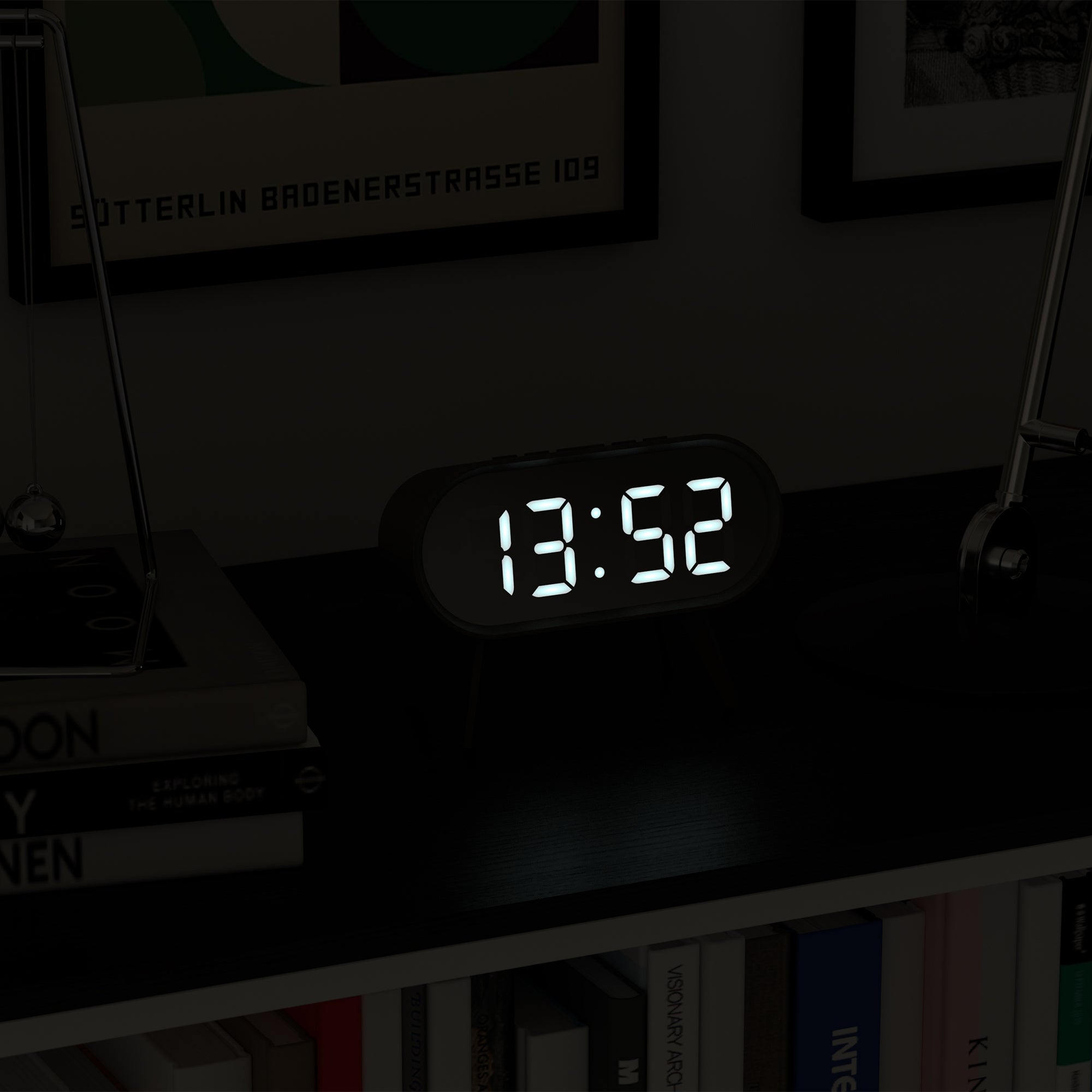 Grey LED alarm clock with illuminated digital time display 13:52, oval case