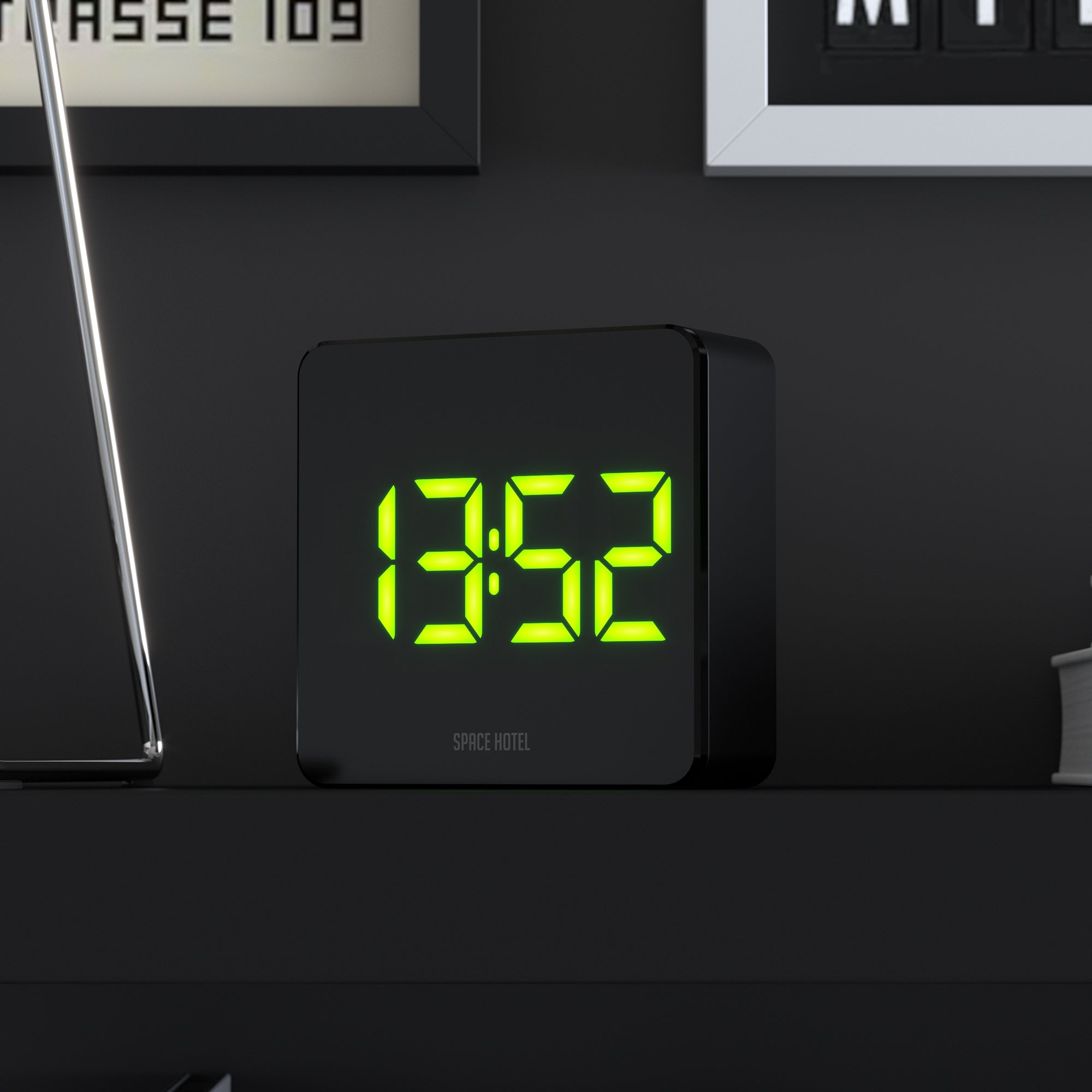 Black alarm clock with green LED digits and Space Hotel logo on front