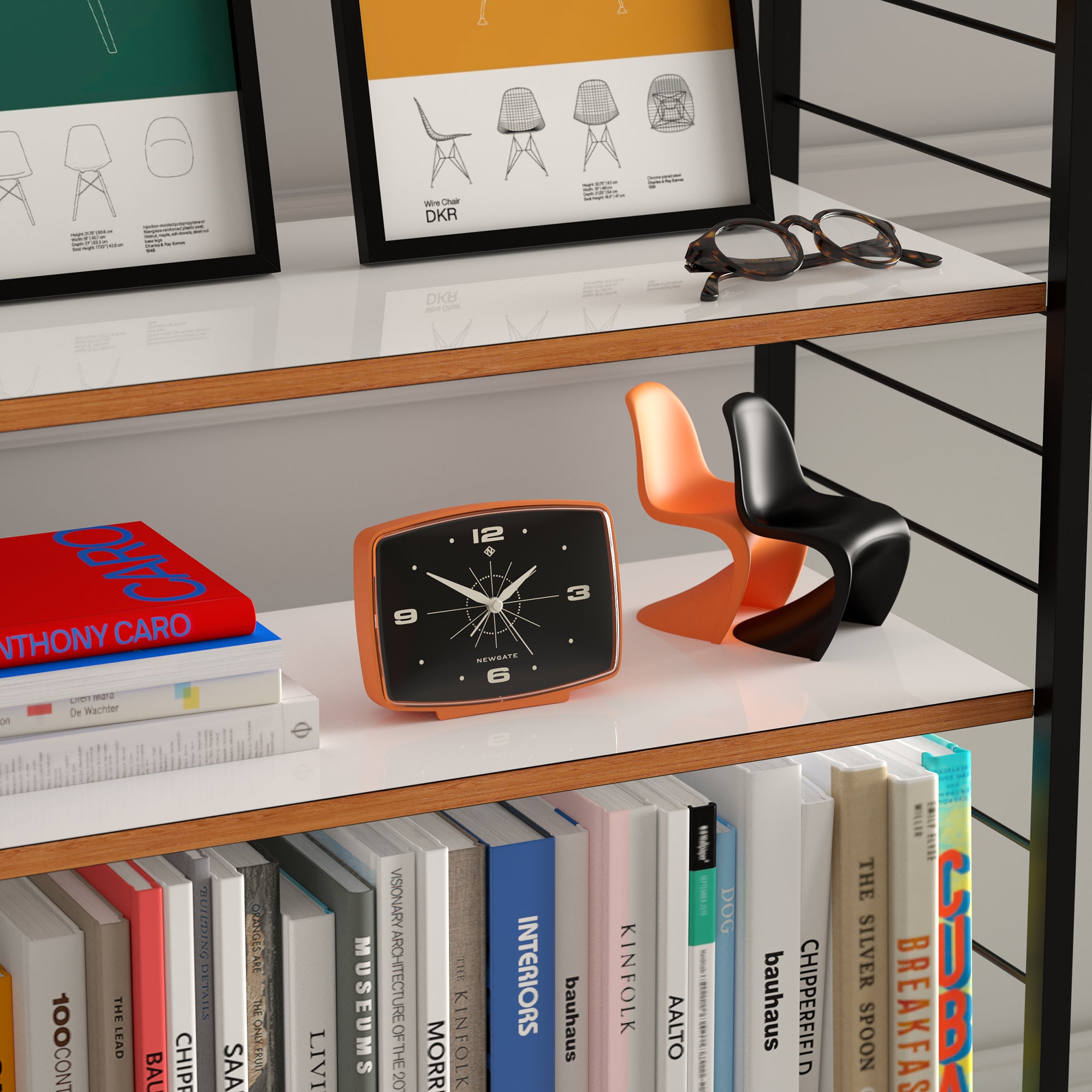 Orange alarm clock on shelf, black dial with white hands and hour markers