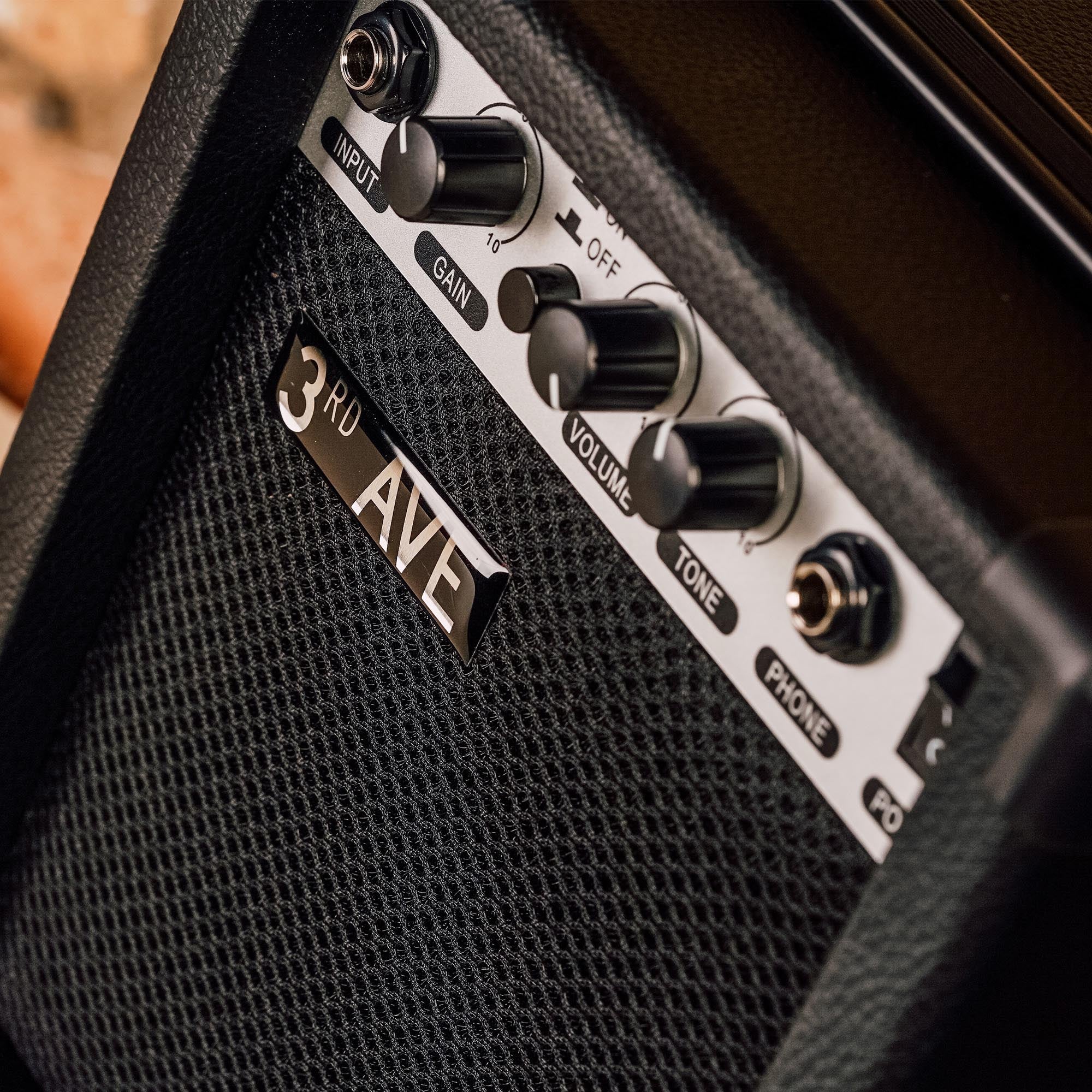 10W guitar amplifier front controls: input, gain, volume, tone knobs and phone jack, black