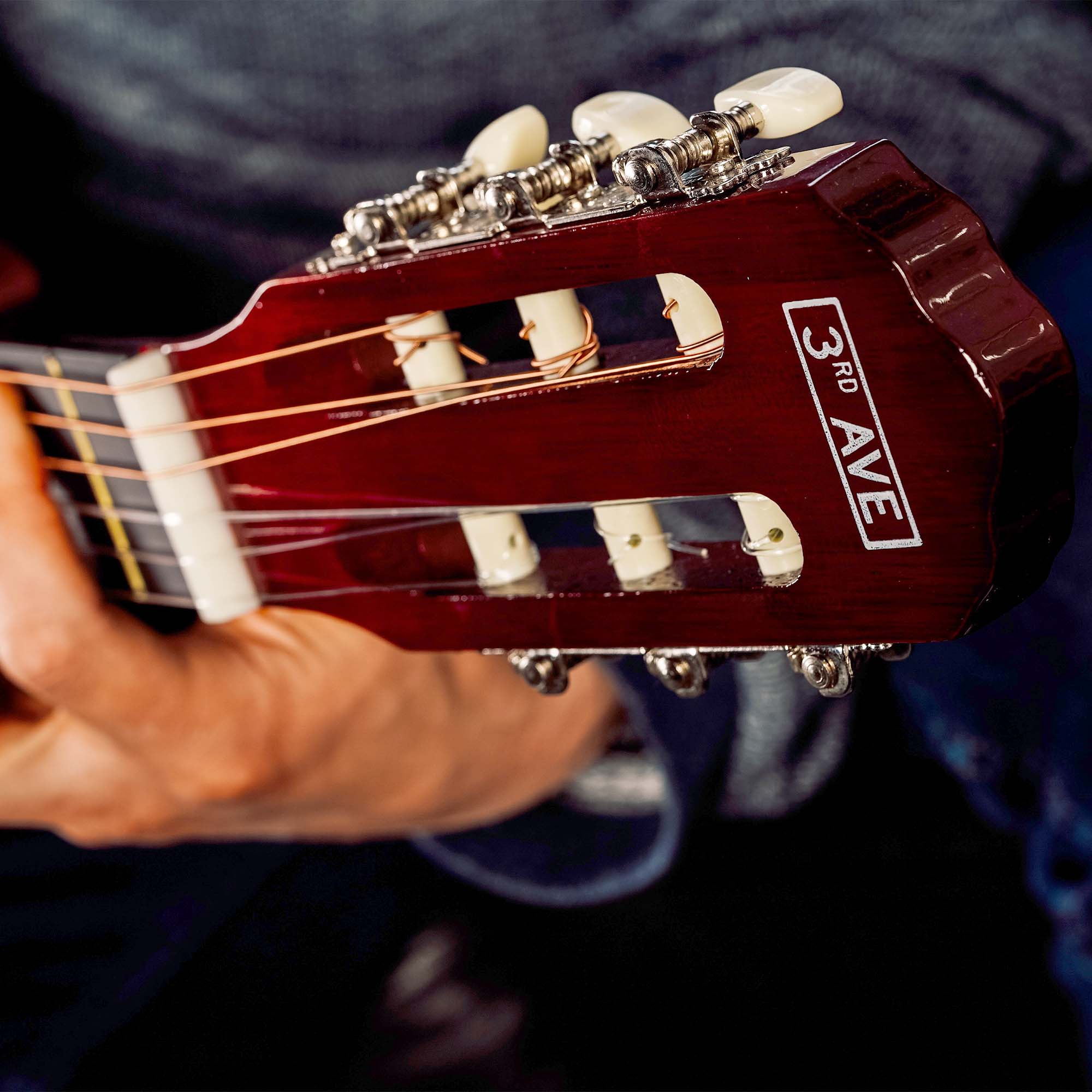 Red classical guitar headstock with RAVE logo and tuning pegs