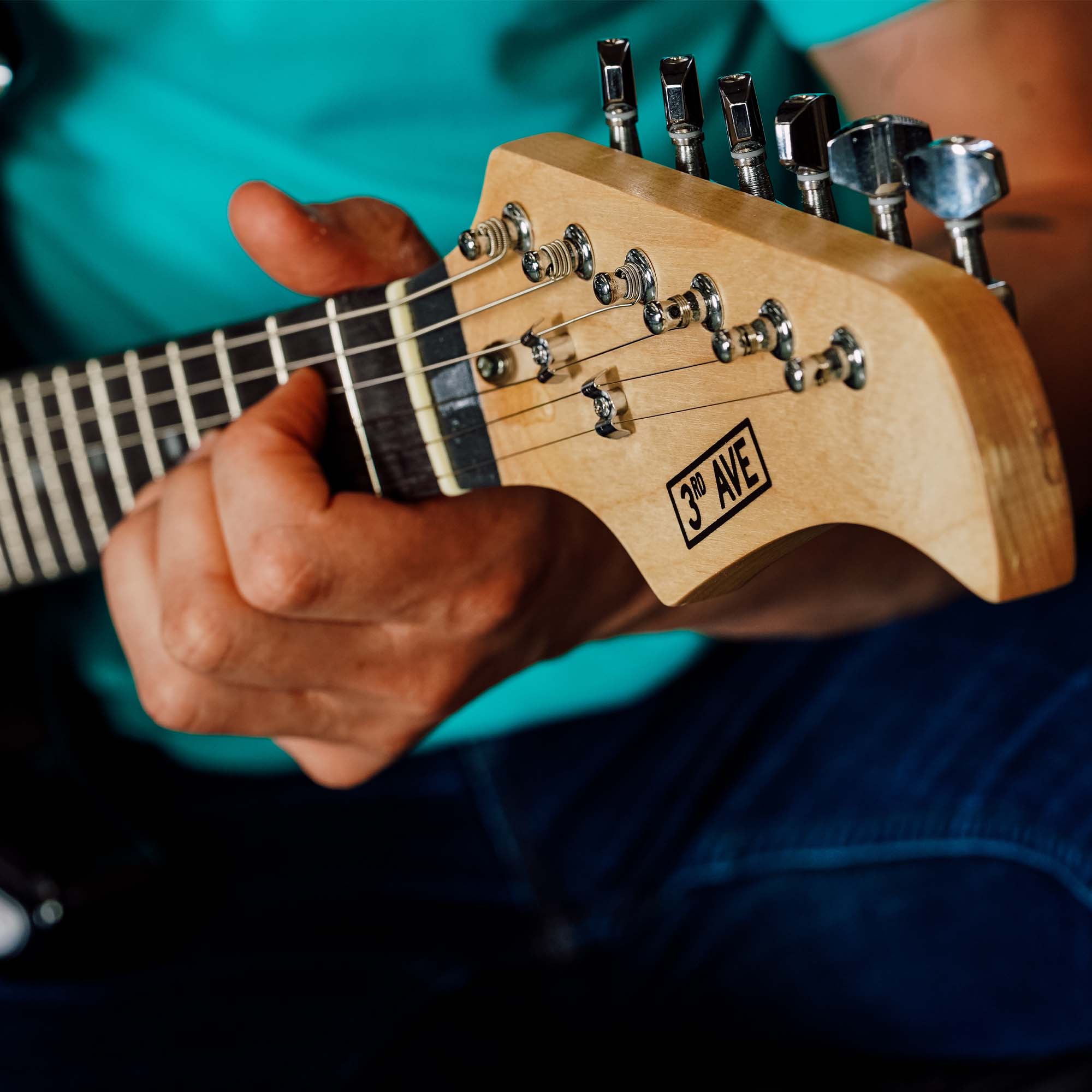 Red electric guitar headstock with tuning pegs and maple neck