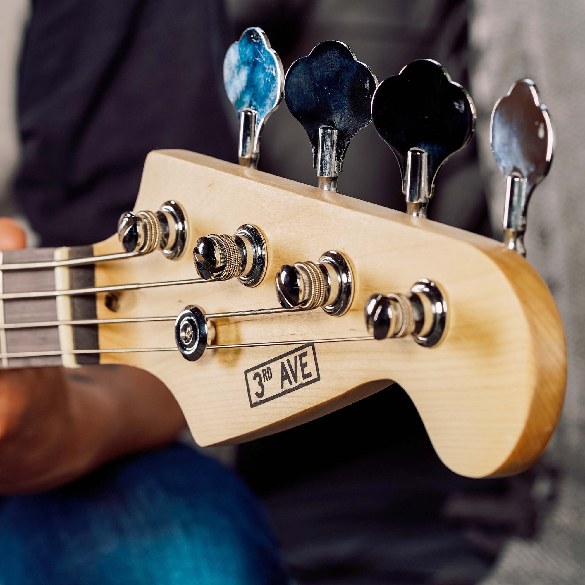 Bass guitar headstock with tuning pegs and “3rd Ave” logo