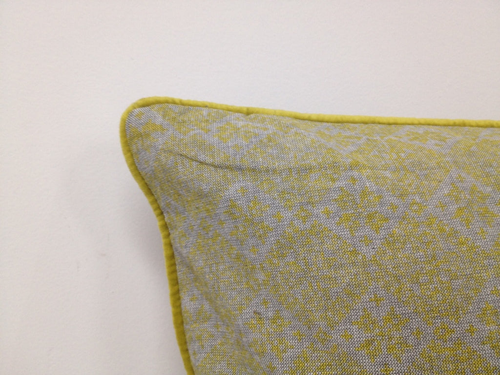 Mustard yellow cushion cover corner with geometric weave pattern