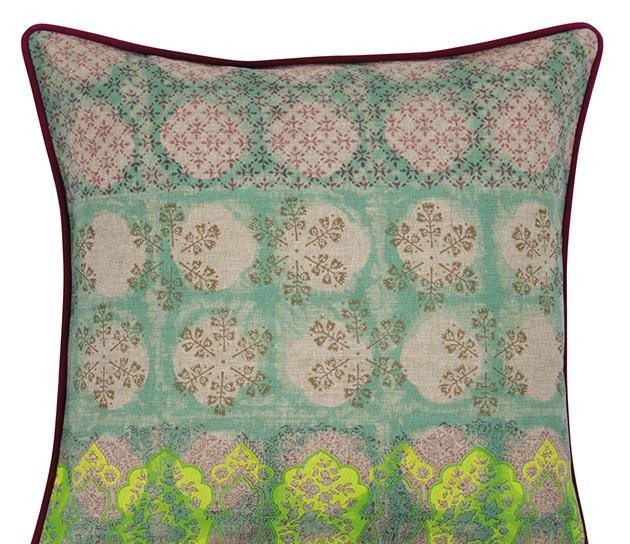 Multicoloured cushion cover close-up with teal background and beige circular medallion pattern