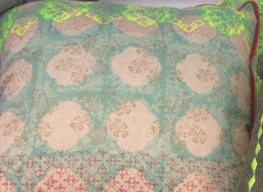 Teal cushion cover fabric with beige circular motifs and red border piping detail