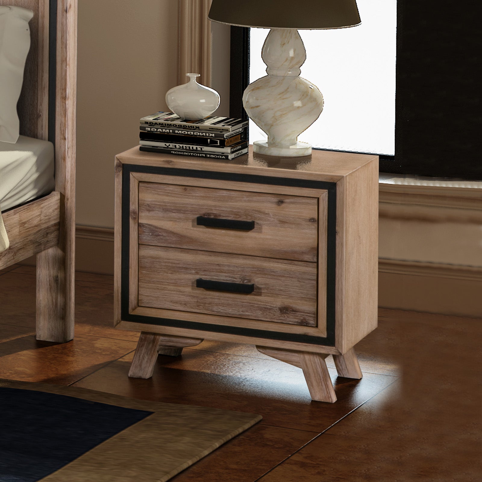 Acacia wood bedside table with two drawers, black pulls, and decorative lamp