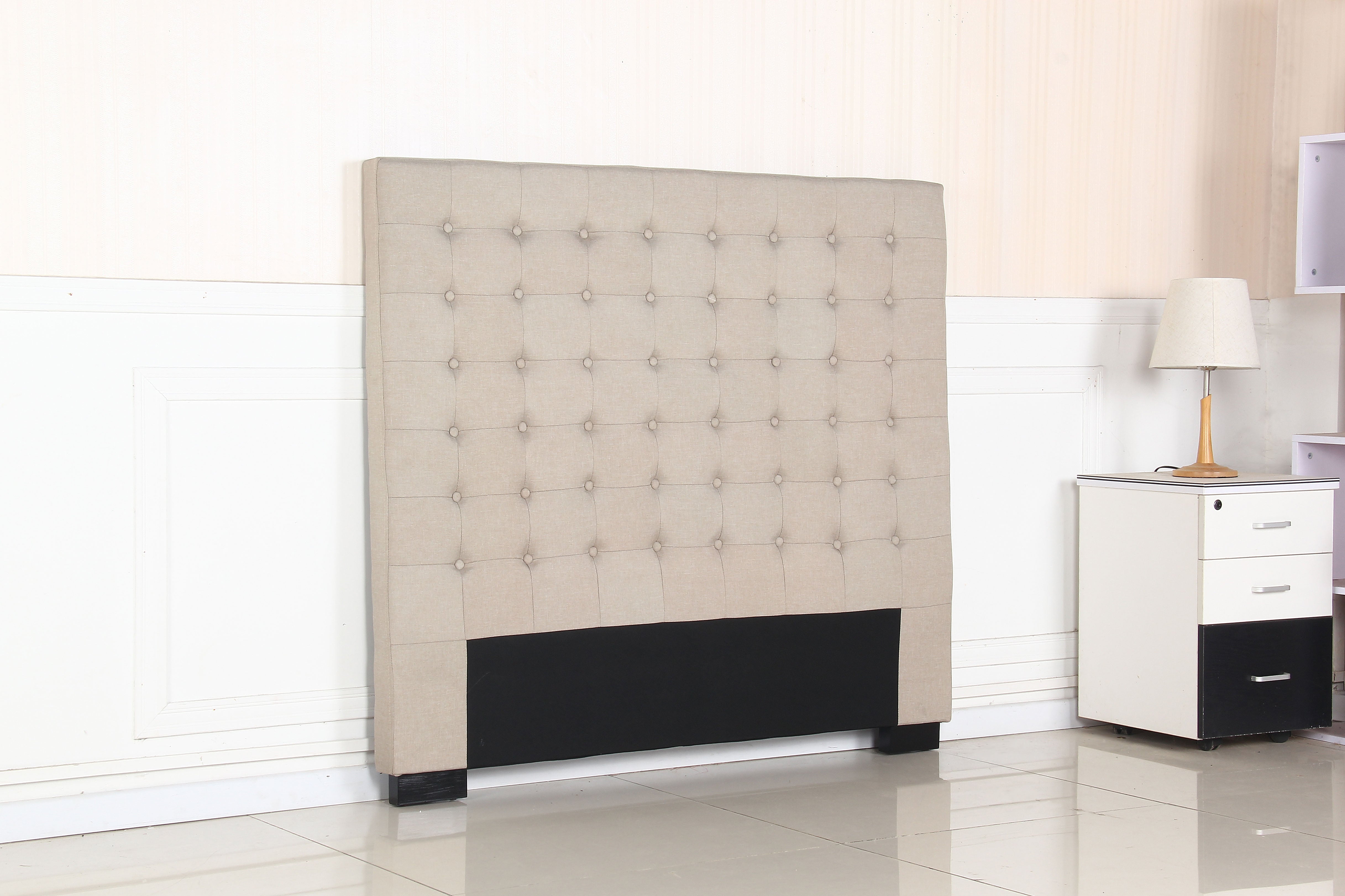 Beige tufted fabric headboard with round buttons and dark lower panel