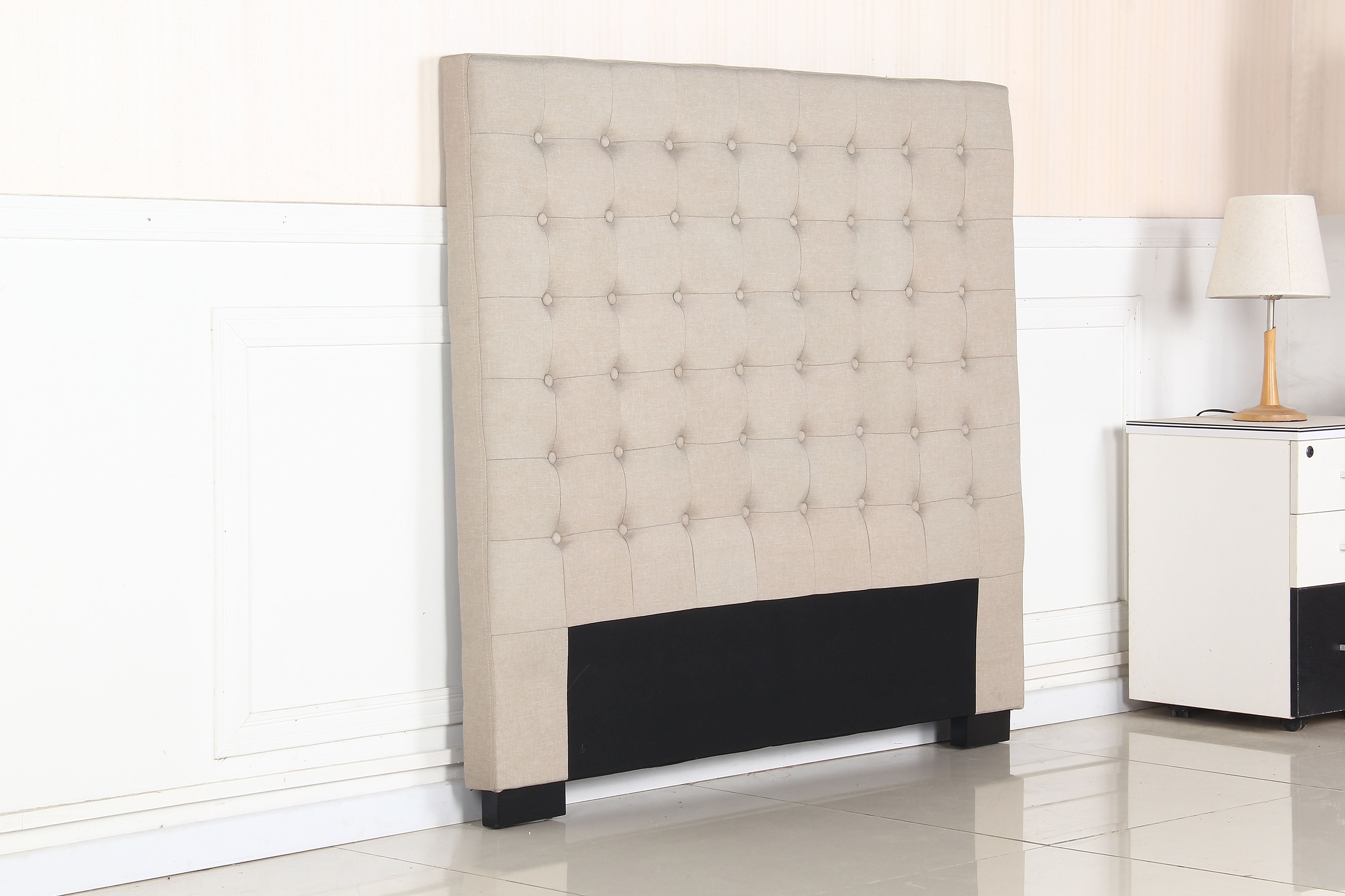 Beige upholstered headboard with tufted buttons and dark base panel