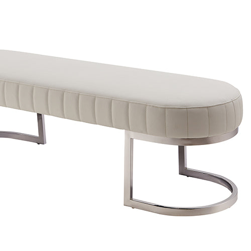Padded bench chair seat with light beige quilted paneling and polished stainless steel leg