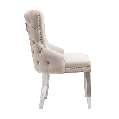 Beige velvet dining chair with diamond tufting, studded arm edge, and stainless legs