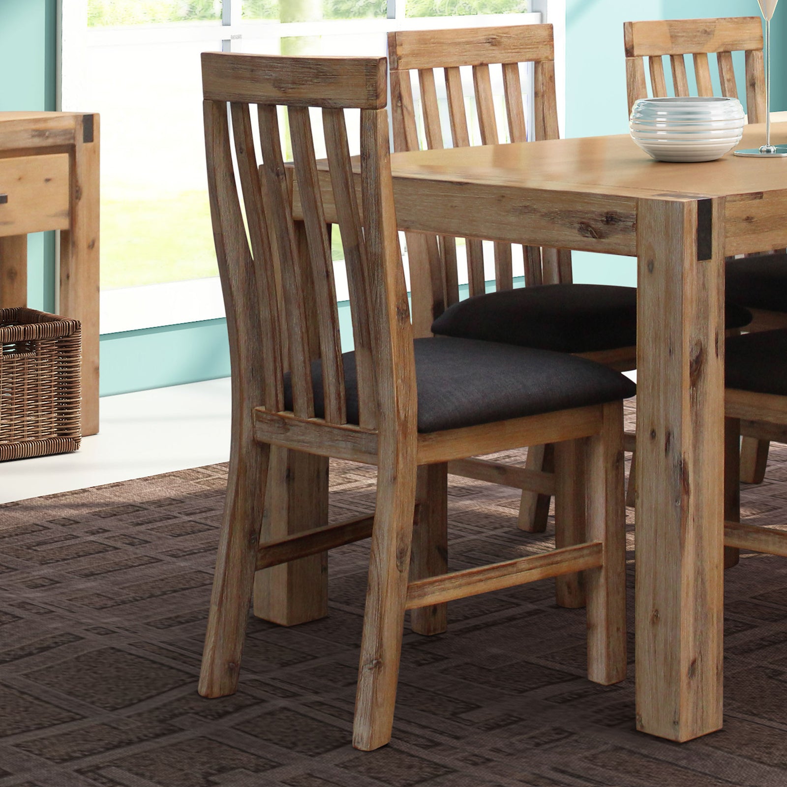 Wooden dining chair with slatted back and dark upholstered seat cushion, acacia tone