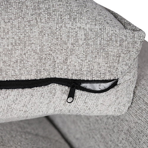 Upholstered armrest corner with visible zipper trim and textured light gray fabric