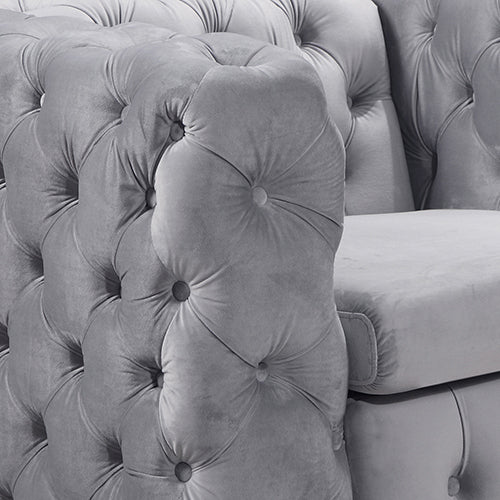Grey velvet chair back with deep tufting and cushioned armrest