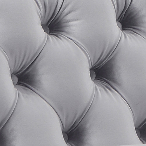 Grey velvet seat cushion detail with tufted channel seams and button
