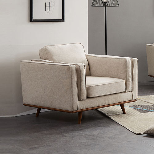 Beige upholstered armchair with sloped arms, wooden base, and backrest