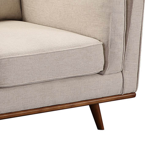 Beige fabric armchair close-up of seat cushion and stitched arm panel