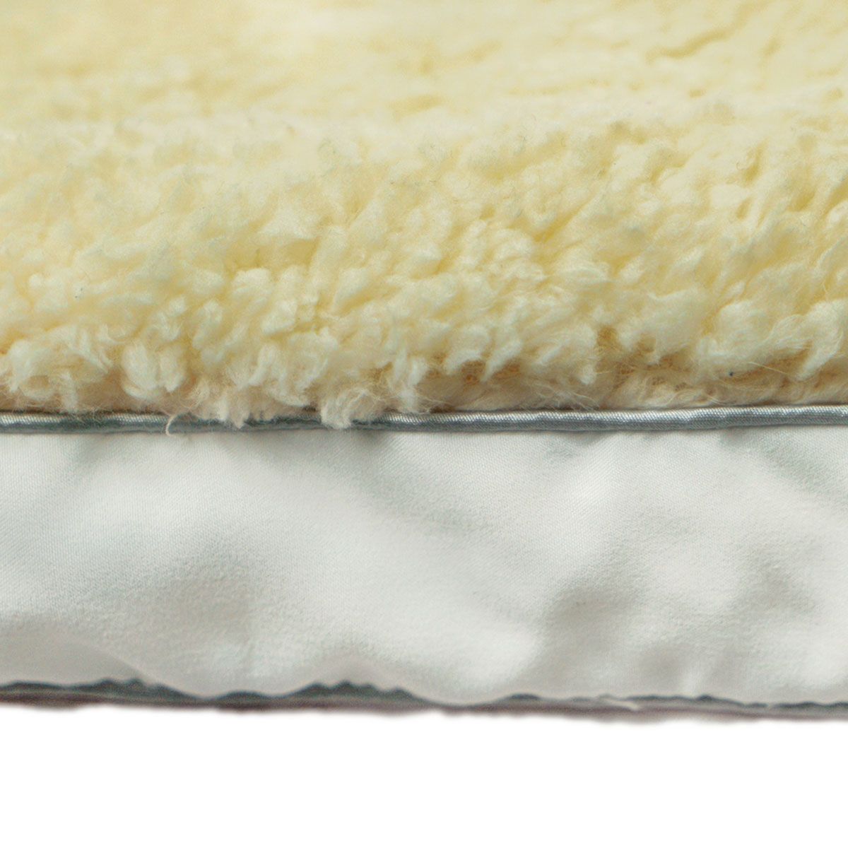 Cream sherpa topper edge view showing gray underside backing