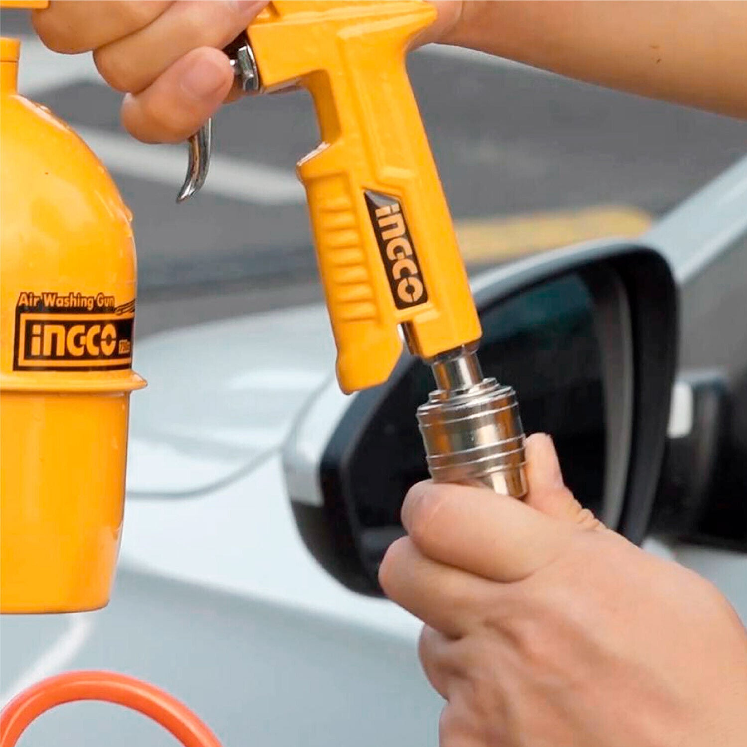 Ingco spray gun connected to hose, applying air to a vehicle tire valve