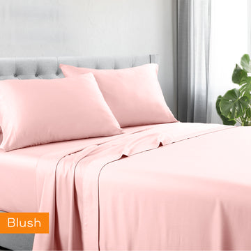 Blush cotton sheet set with matching pillowcases, neatly styled on a bed