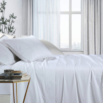 White bamboo cotton sheet set with fitted and flat sheets, neatly made bed