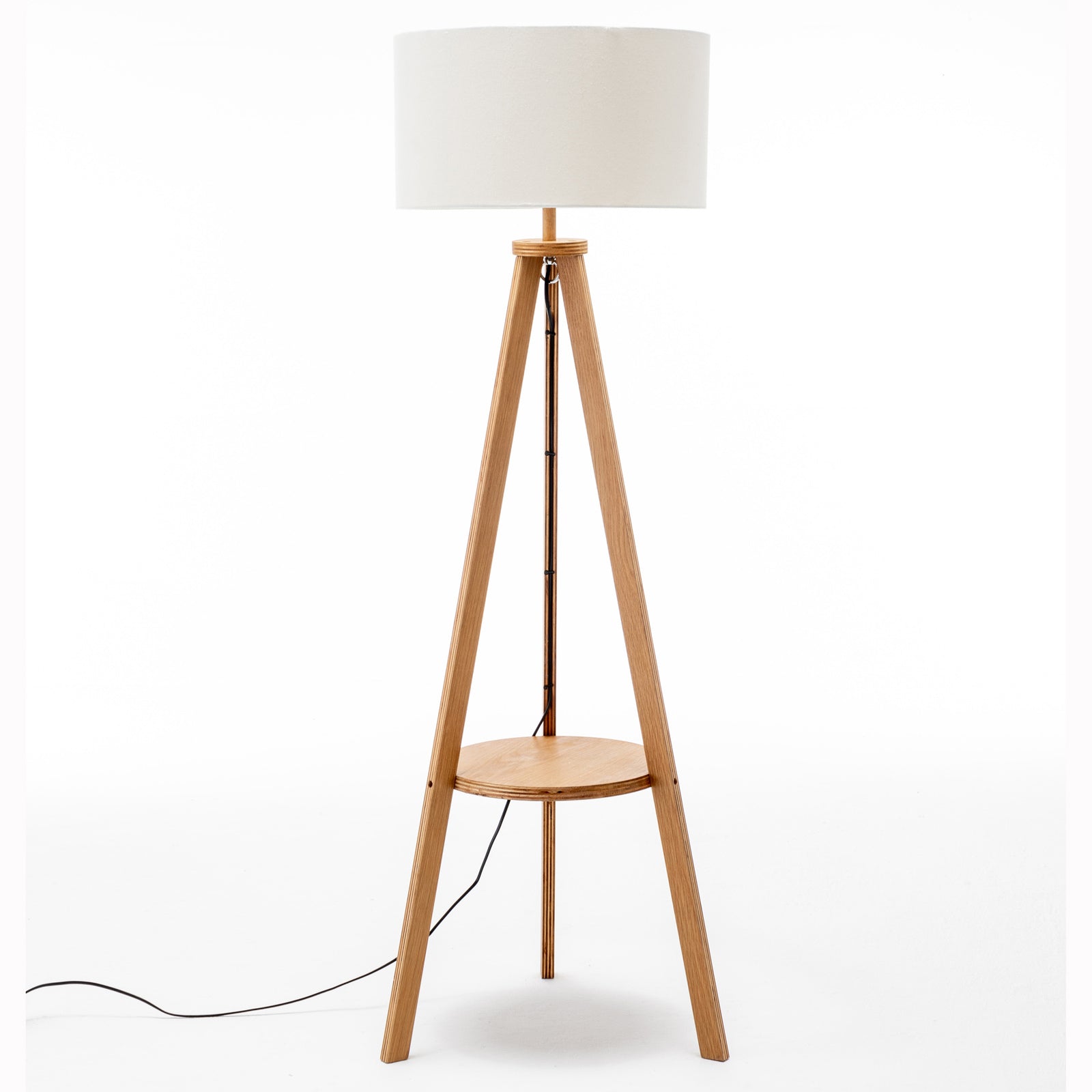 Tripod floor lamp with off-white linen drum shade and round wooden side shelf