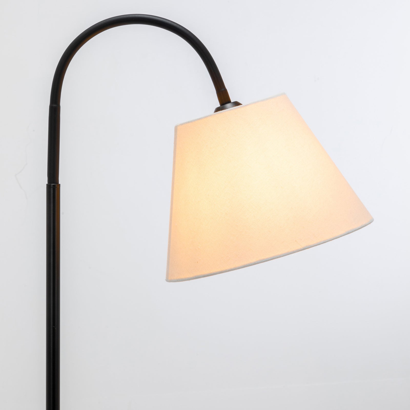 Tripod lamp with curved black stand and cream fabric shade