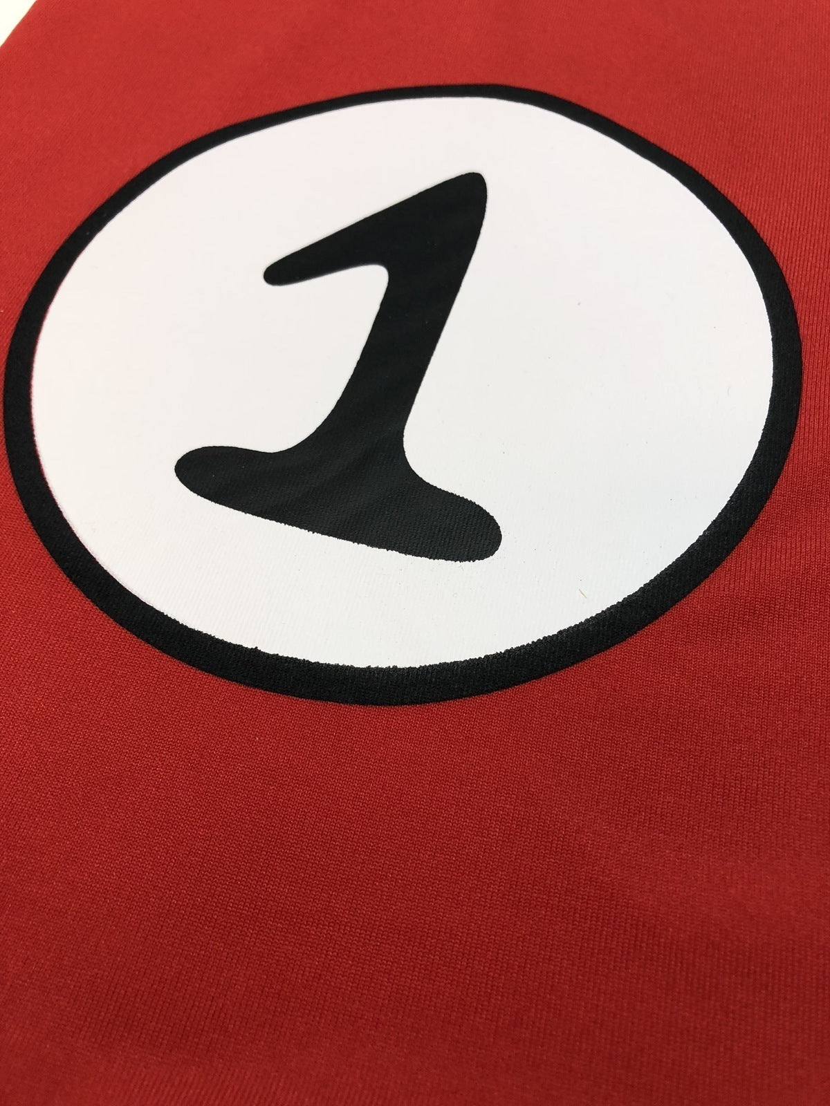 Close-up of red top print: white circle with black number 1 inside