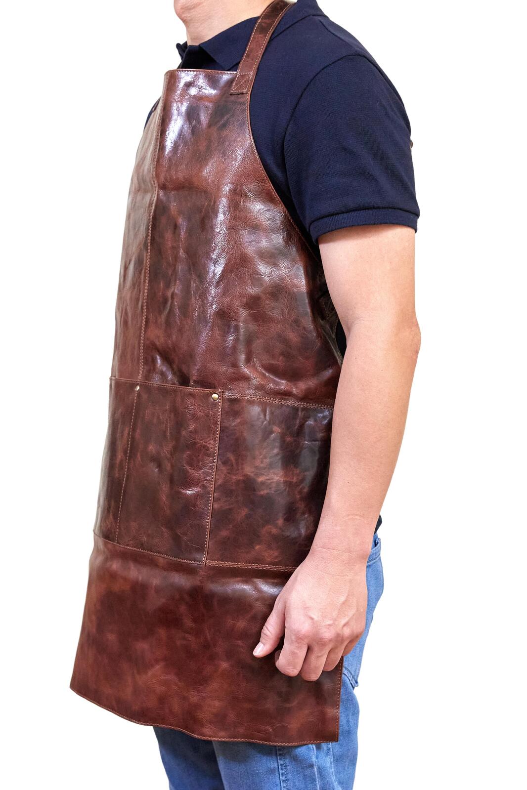 Cognac leather apron shown from the side with front pocket and adjustable strap