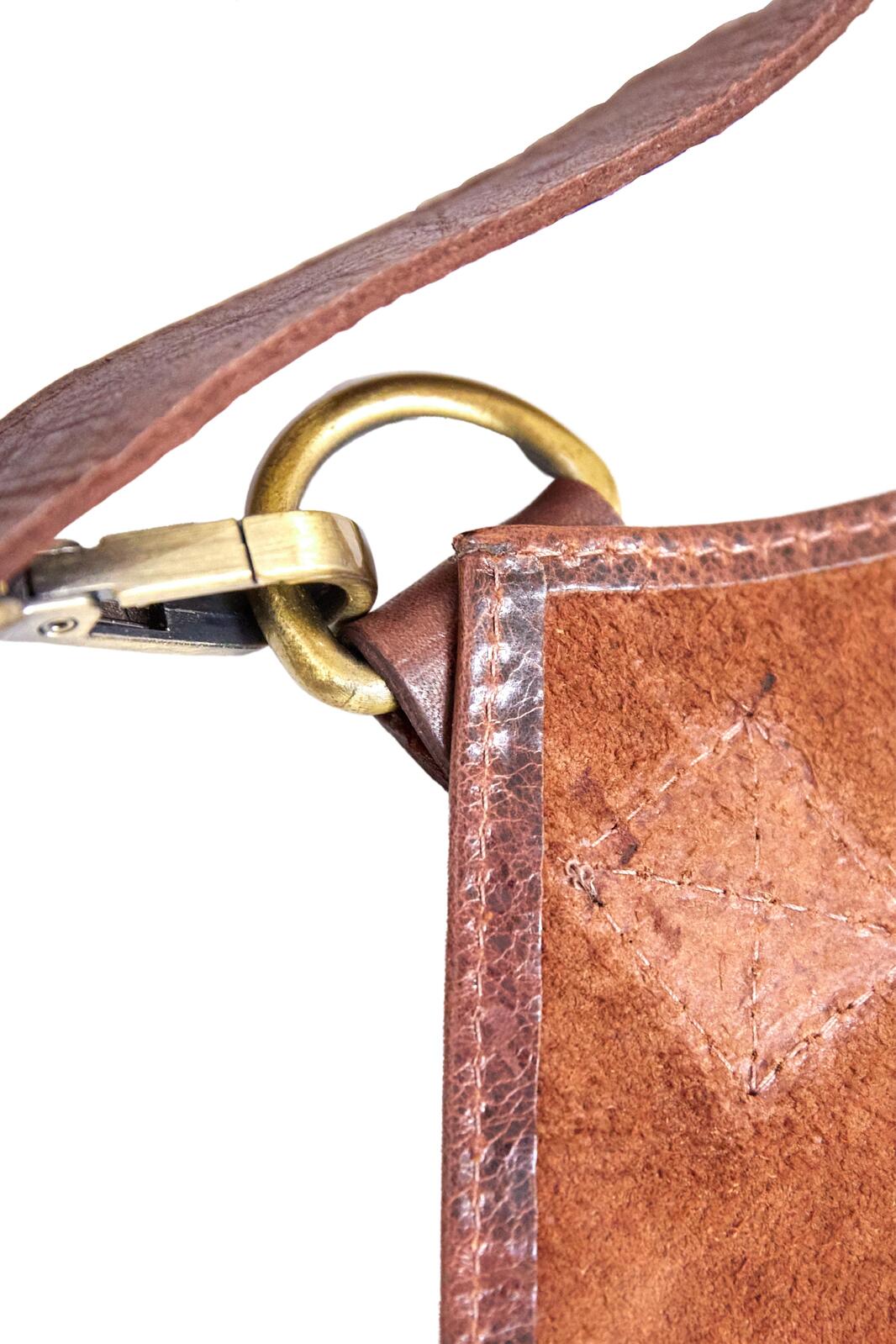 Close-up of brass clasp and leather strap on a cognac leather apron