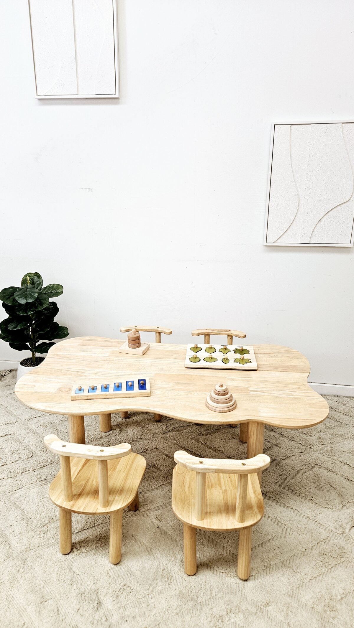 Wooden cloud-shaped kids table with four light wood chairs and small board pieces