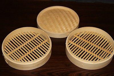 Two round bamboo steamer baskets with lids, woven slat cooking trays