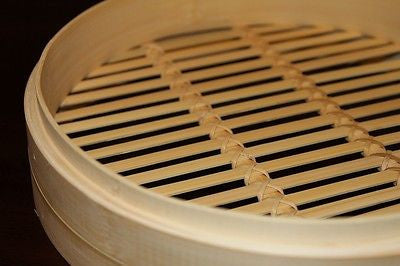 Close-up bamboo steamer basket slats, open grid interior for steaming