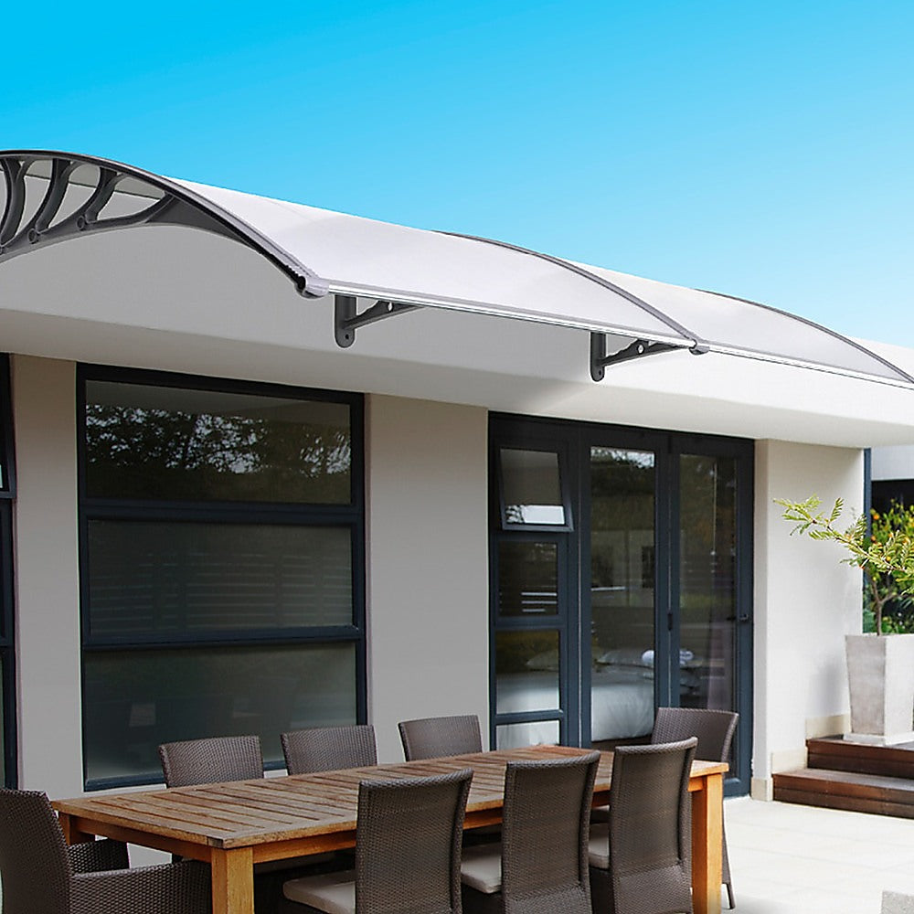 Installed outdoor awning cover with clear panel and gray metal brackets
