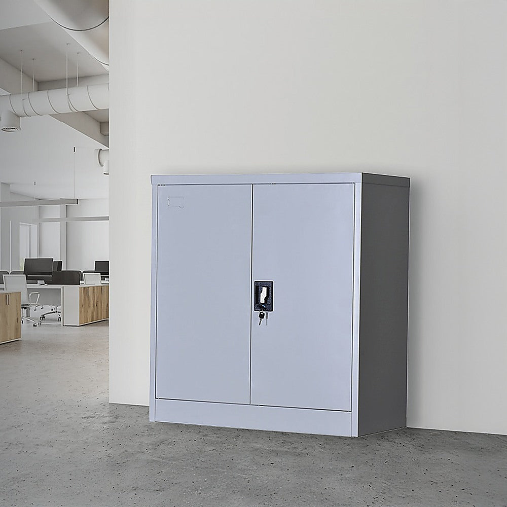 Two-door lockable storage cabinet, light gray metal with key lock on front door.