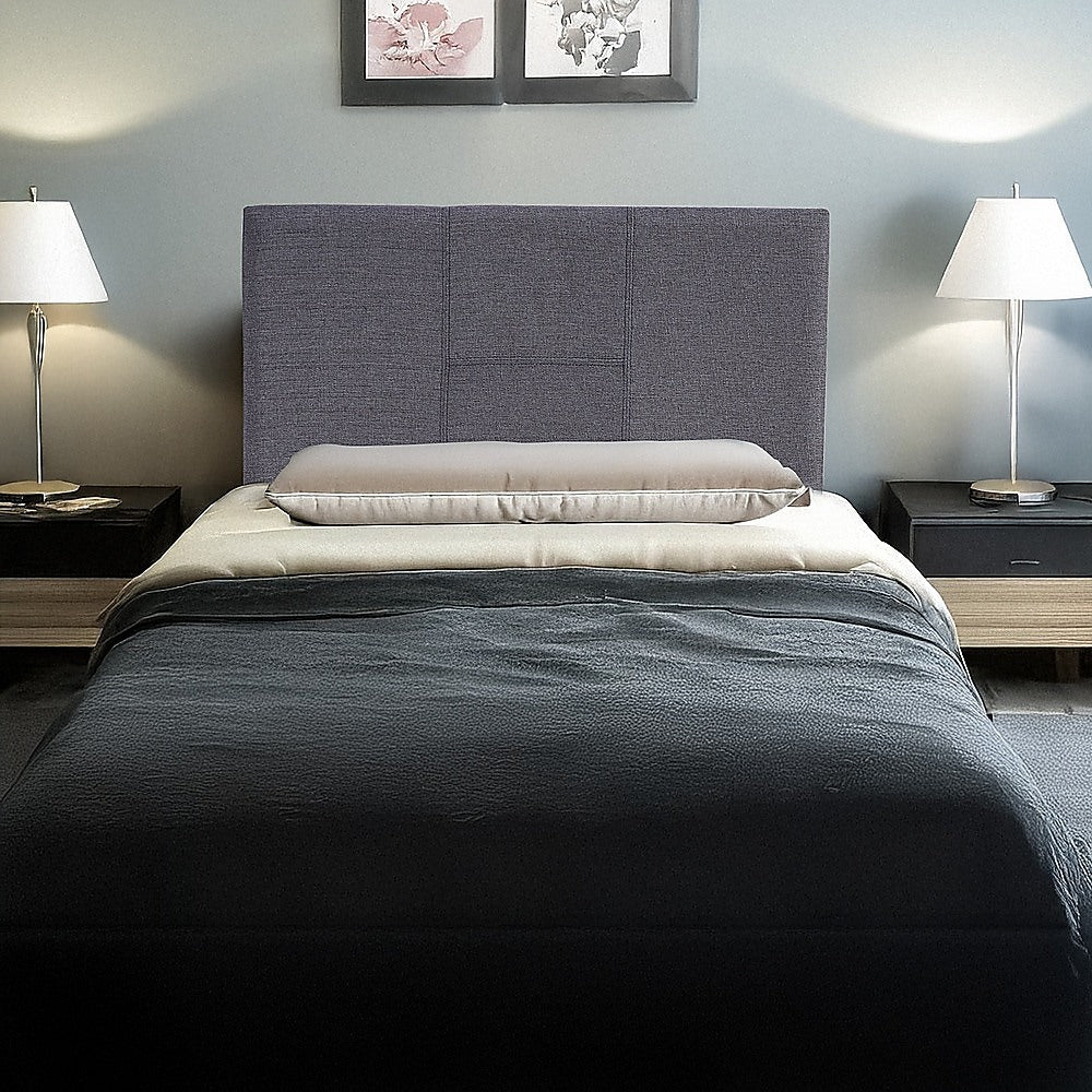 Grey linen single-bed headboard with padded panels and black legs behind bed