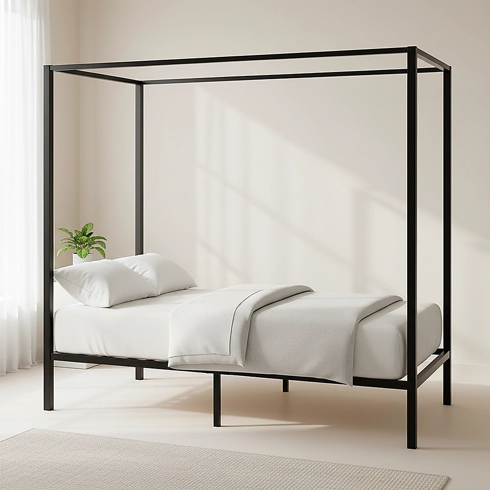 Black four-poster single bed frame with slatted base and white bedding on top.